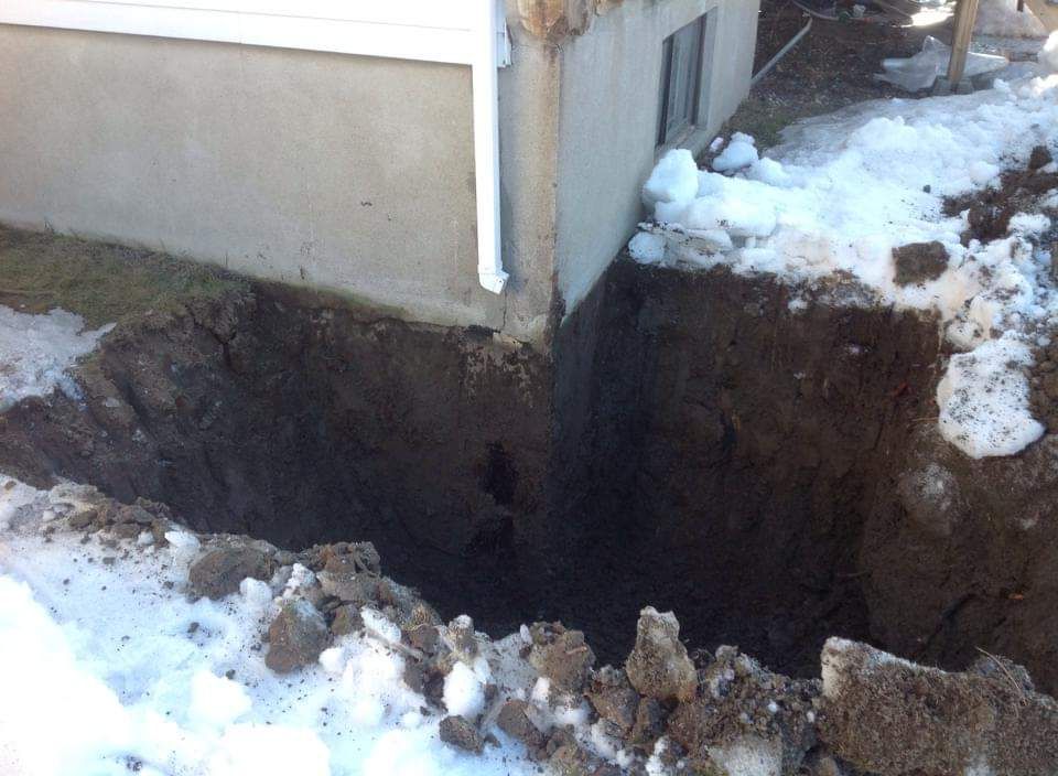 Un grand trou dans le sol devant une maison