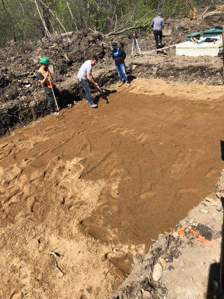 Un groupe de personnes travaillent sur un champ de terre.