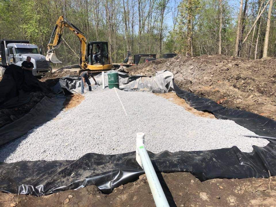 Un chantier de construction avec un bulldozer et un camion en arrière-plan.
