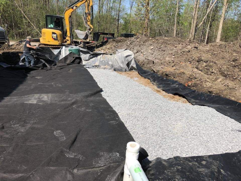 Un chantier de construction avec une excavatrice jaune et un tas de gravier.