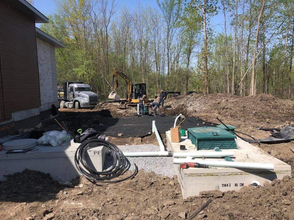 Une maison est en construction au milieu d'un champ de terre.