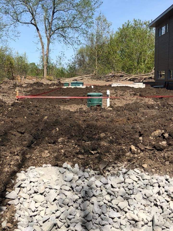 Une maison est en construction au milieu d'un champ de terre.