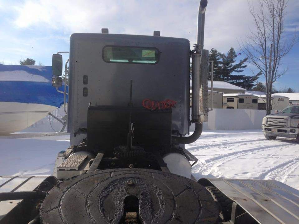 Un camion est garé dans la neige avec une bâche bleue qui le recouvre
