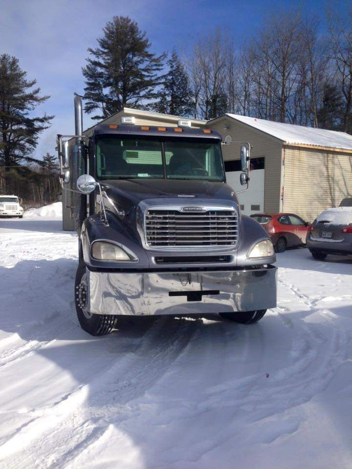 Un camion est garé dans la neige devant un immeuble