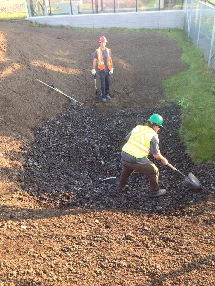 Deux ouvriers du bâtiment travaillent sur un champ de terre.