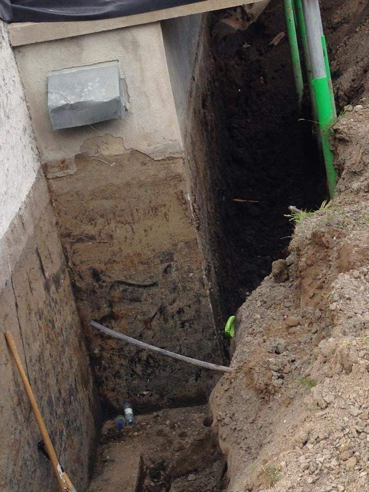 Un trou dans le sol avec un tuyau vert qui en sort
