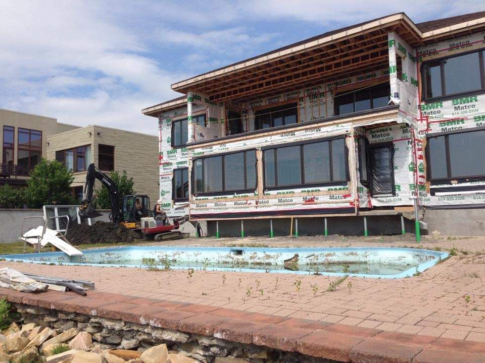 Une grande maison en construction avec une piscine devant