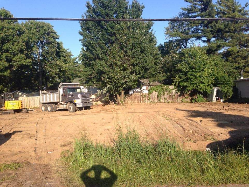 Un camion-benne est garé au milieu d'un champ de terre.
