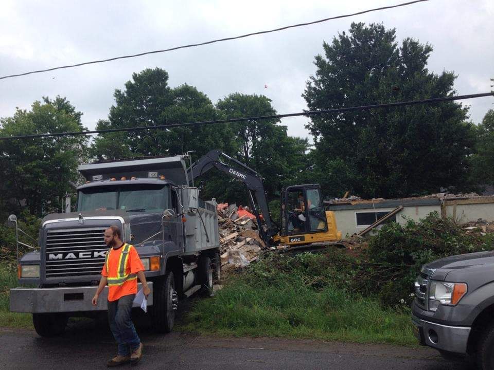 Un homme marchant devant un camion-benne mack