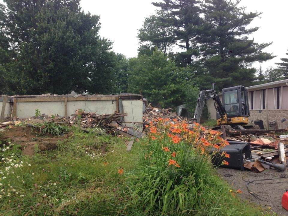 Une maison est en train d'être démolie avec un bulldozer au premier plan
