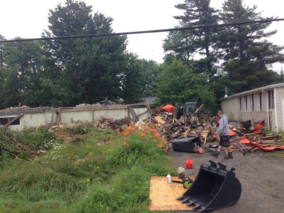 Un homme se tient devant un chantier de démolition