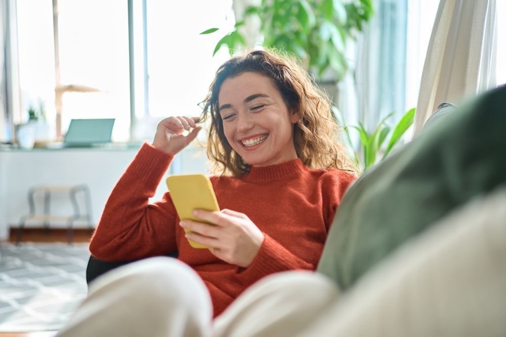 Happy Woman On Mobile Phone — Michael Andrews Taxation & Accounting Services In Pacific Paradise, QLD