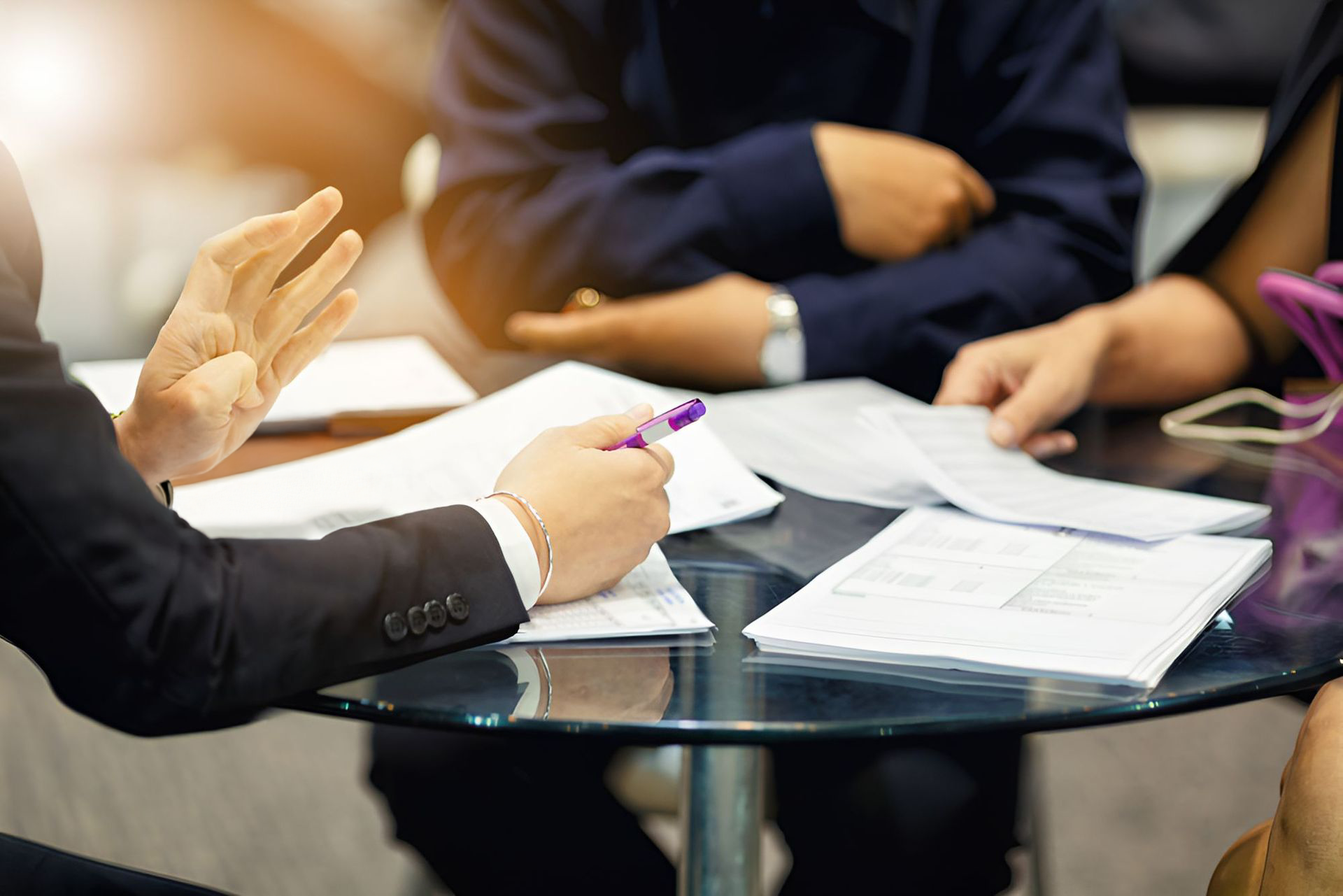 A Group Of People Are Sitting Around A Table Talking To Each Other — Michael Andrews Taxation & Accounting Services In Pacific Paradise, QLD