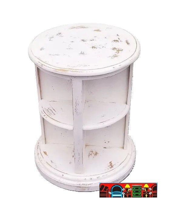 A round library end table in weathered white, with shelves.