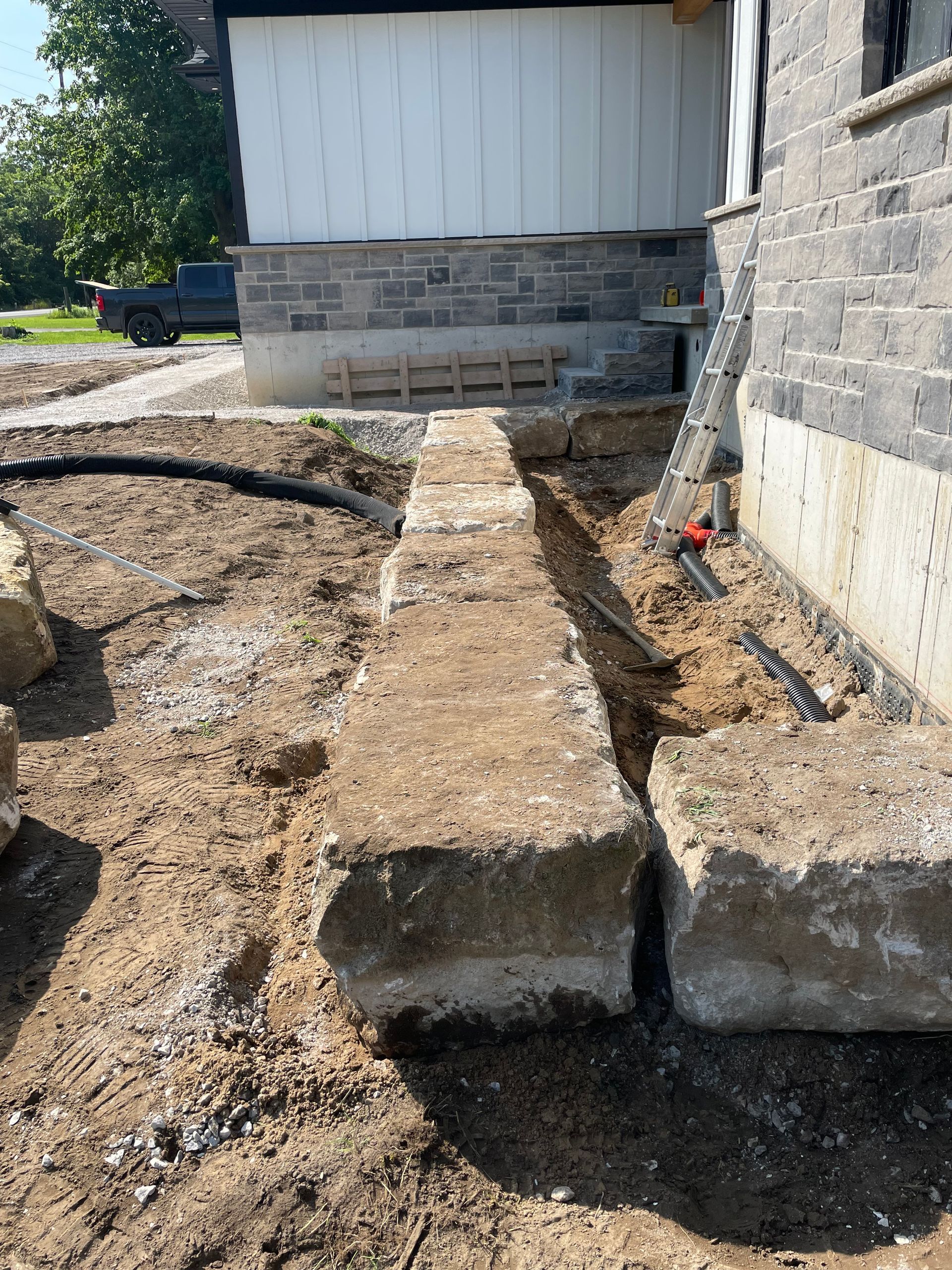 Landscape large stones near house to create flowerbed.