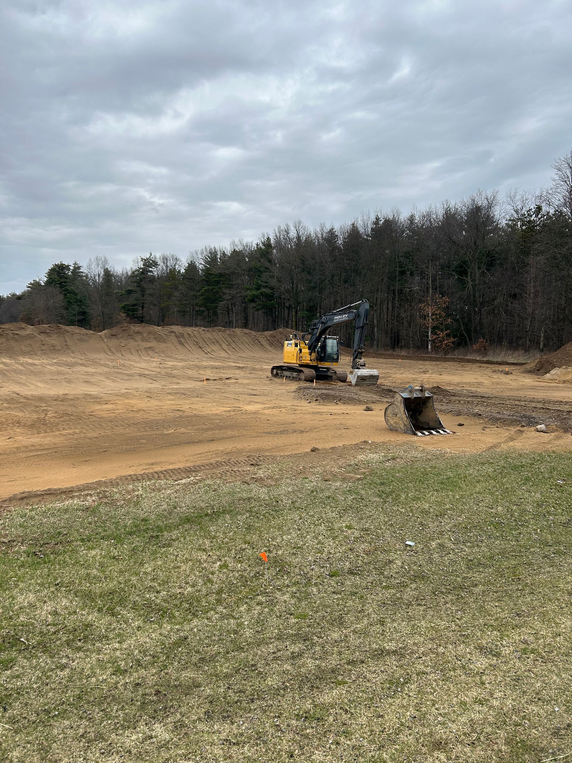 Excavator with different attachments preparing footings and foundation.
