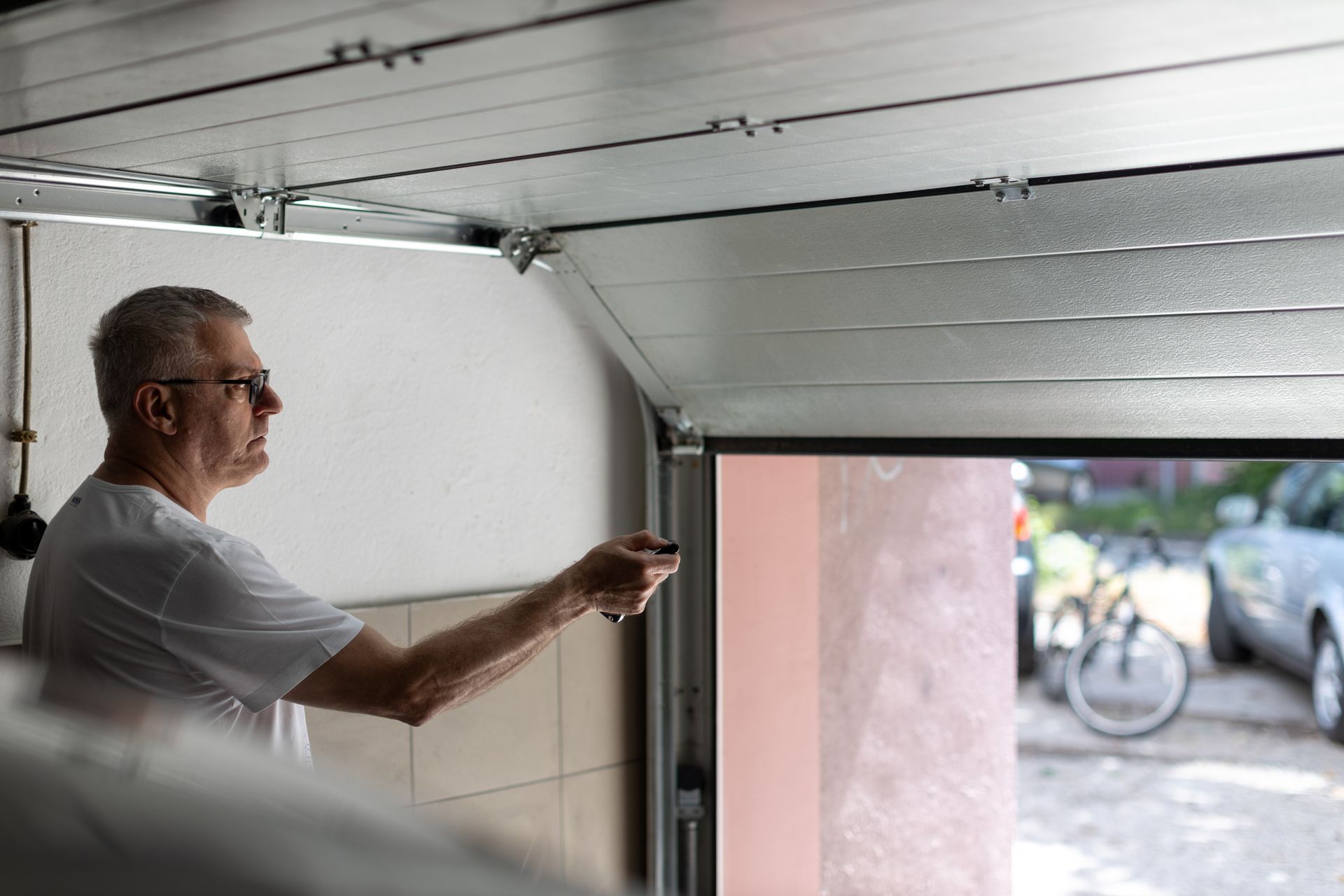 Un uomo sta aprendo la porta di un garage con un telecomando.