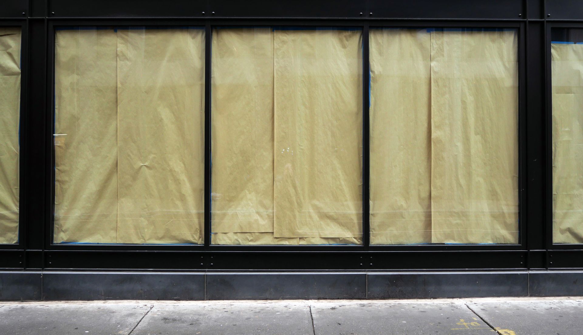 Un edificio con molte finestre coperte di carta marrone.