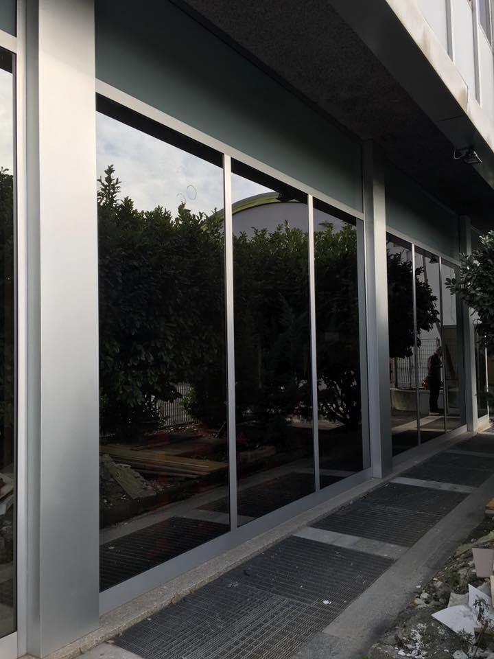 Un edificio con molte finestre e alberi riflessi in esse