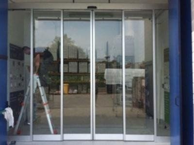 Un uomo è in piedi su una scala davanti a una porta scorrevole in vetro.