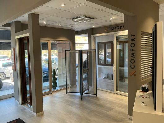 Espositore di ferramenta per porte con vari stili di maniglie su una porta in legno.
