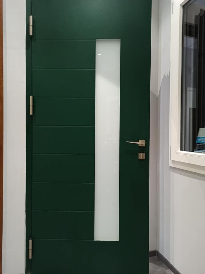 Porta verde con pannello in vetro smerigliato, ferramenta argentata.