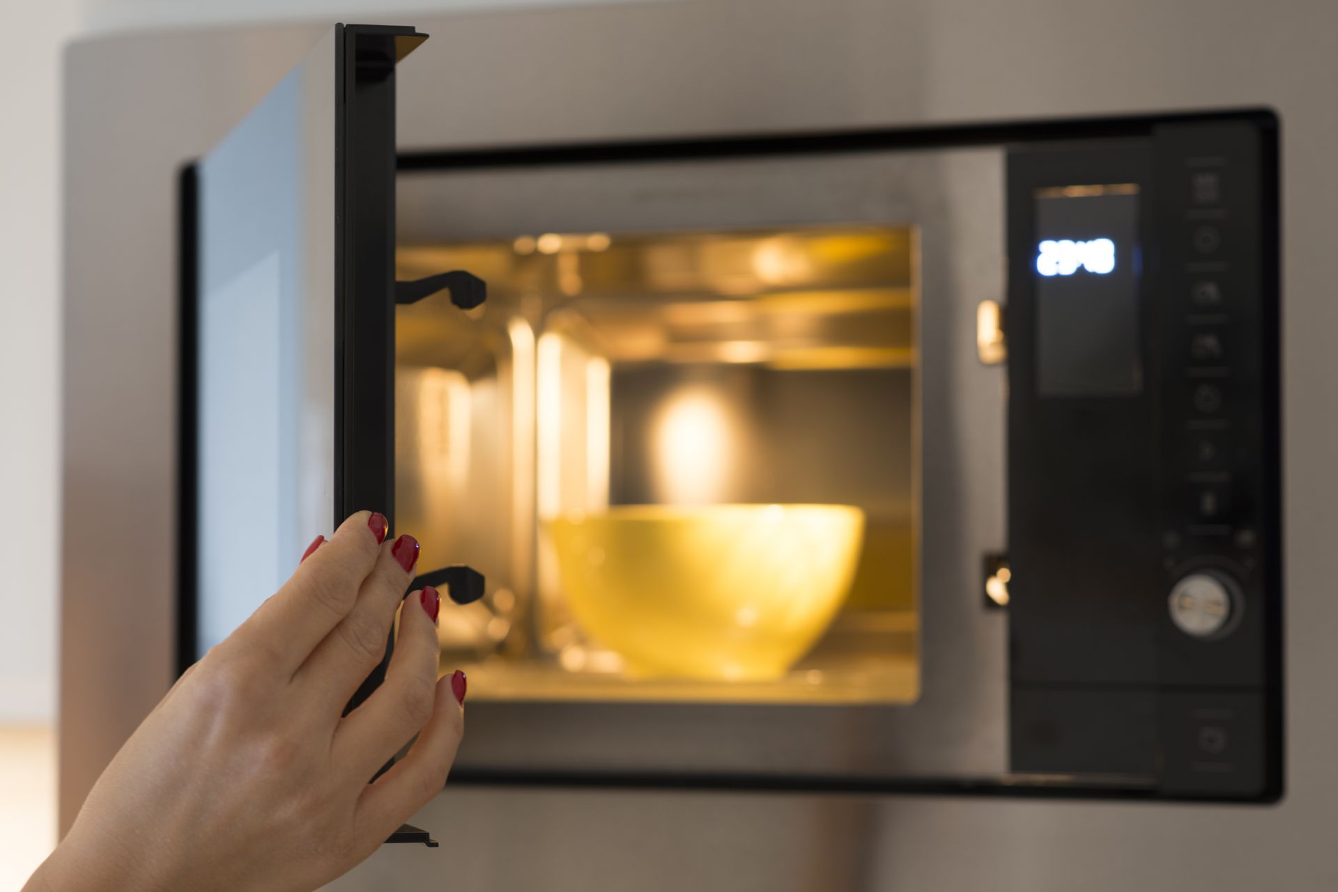 Dishwasher loaded with dishes, against blue cabinets.