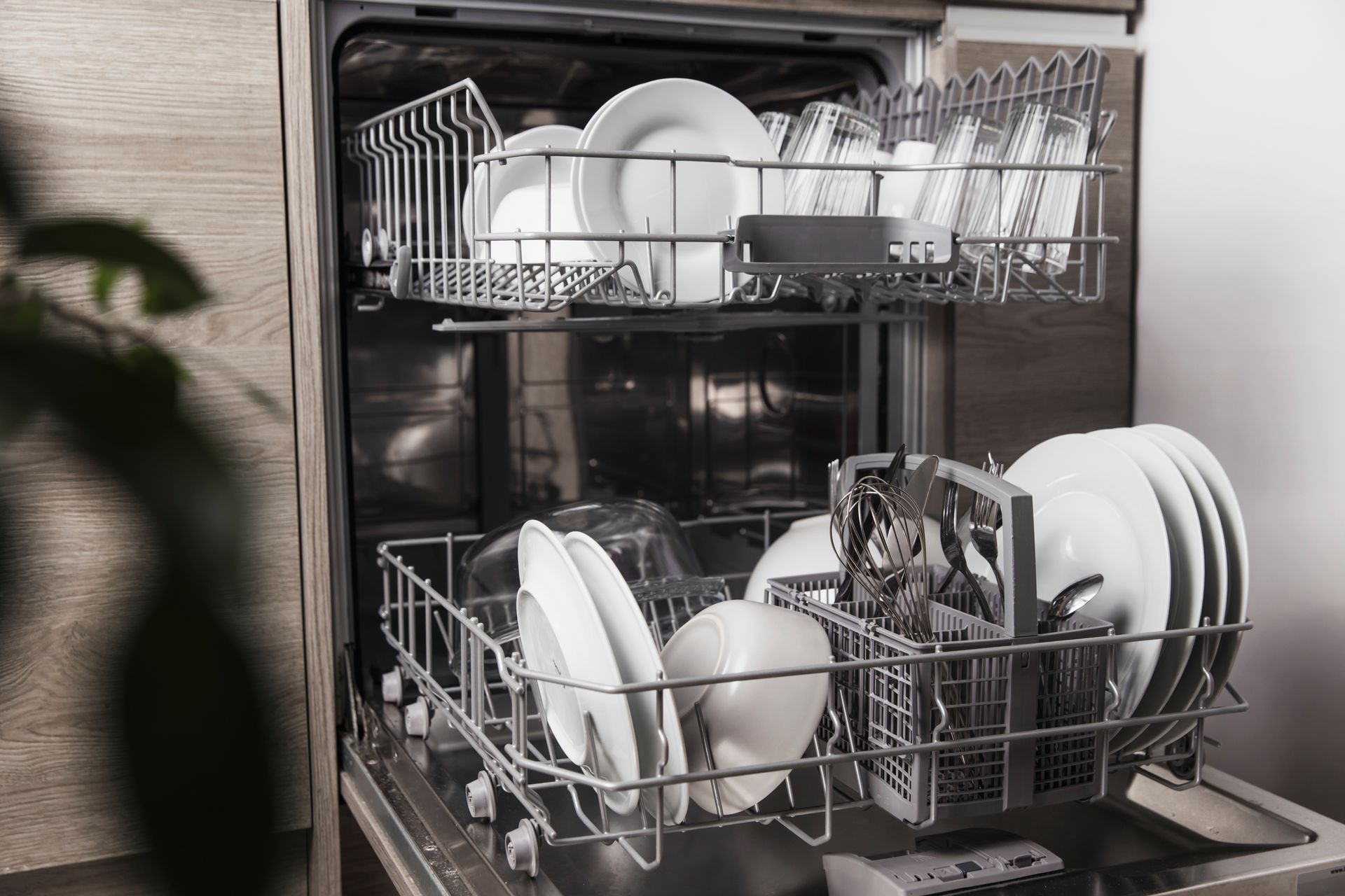 Dishwasher with open door, full of clean white dishes.