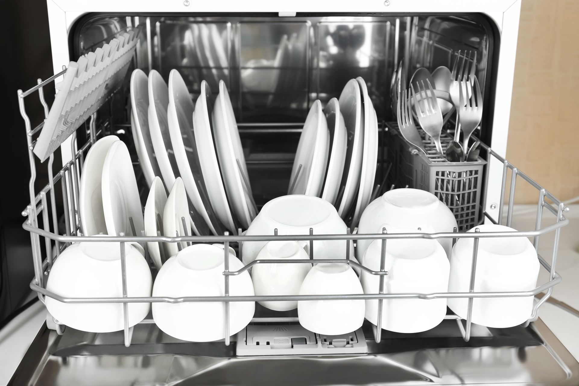 Person opening oven door and adjusting temperature dial.