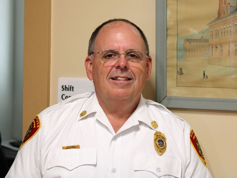a man in a white uniform is standing in front of a painting .