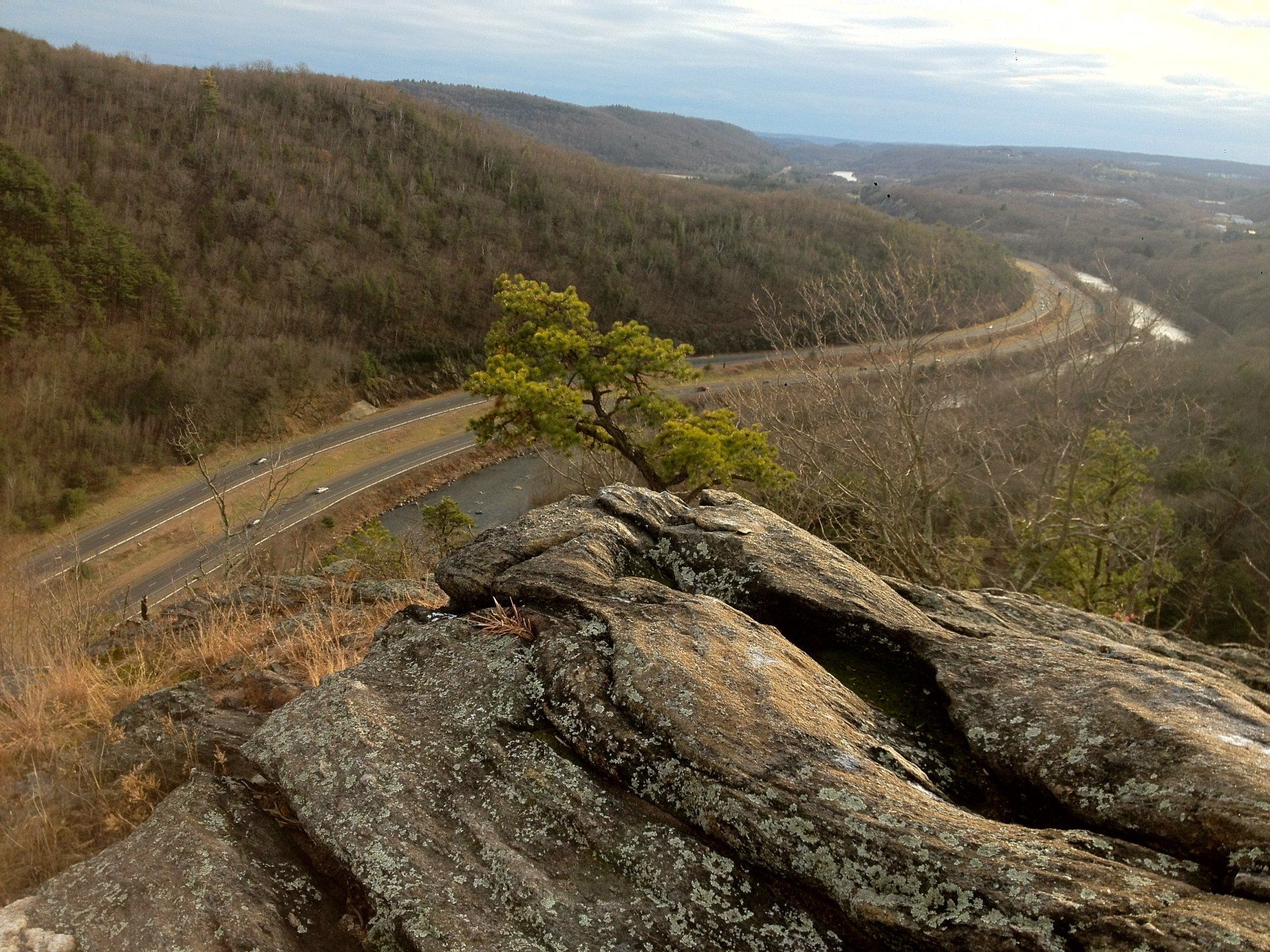 a view of a road going through a valley from a rocky cliff .
