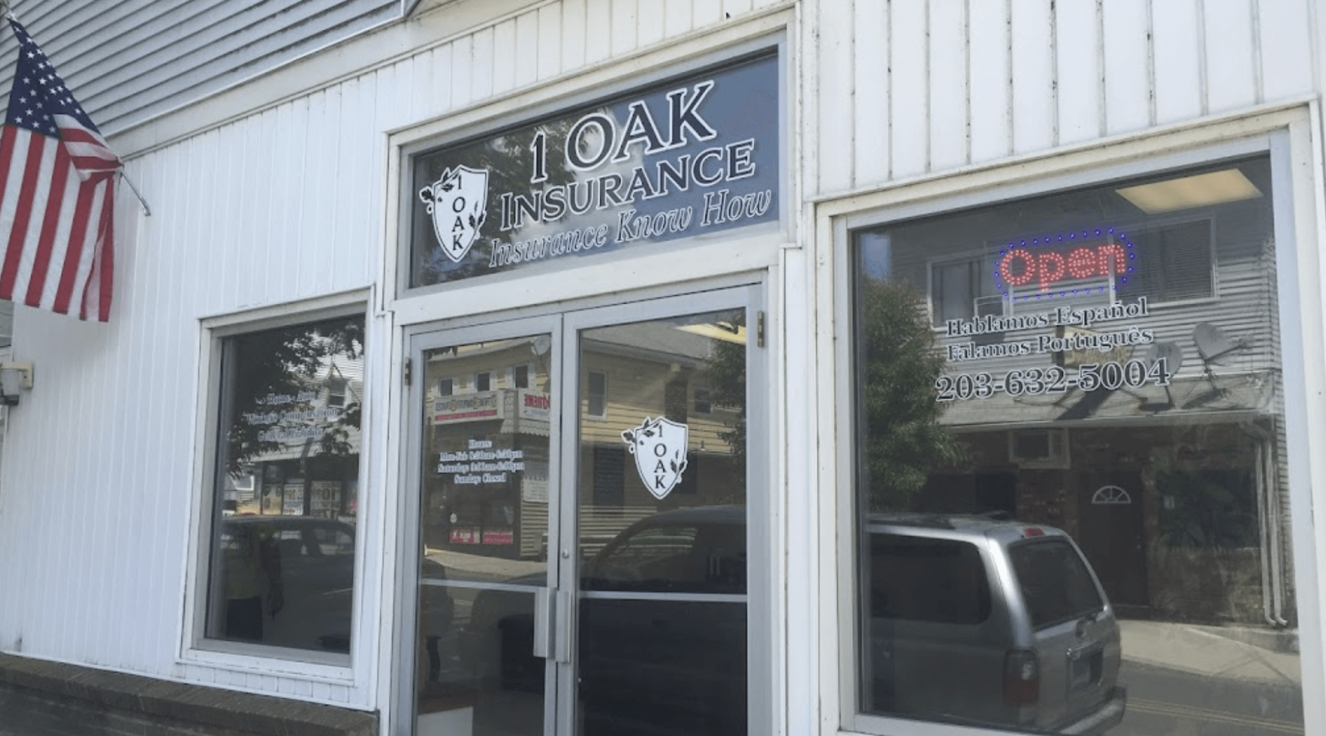 Oak Ridge storefront with white siding, glass door, and an American flag outside