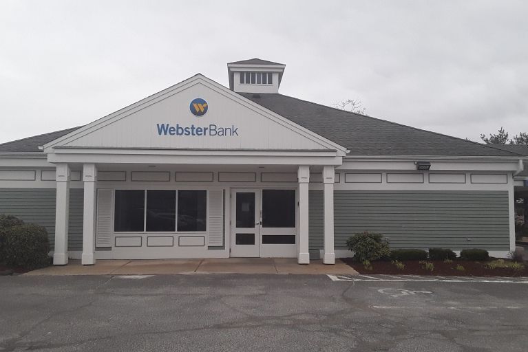 WebsterBank branch building with white columns and gray exterior under an overcast sky