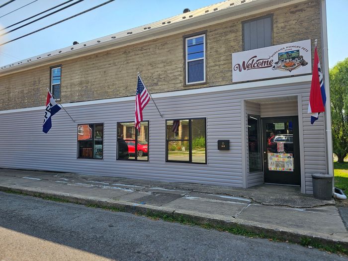 A brick building with a white siding and a sign that says welcome A brick building with a white siding and a sign that says welcome