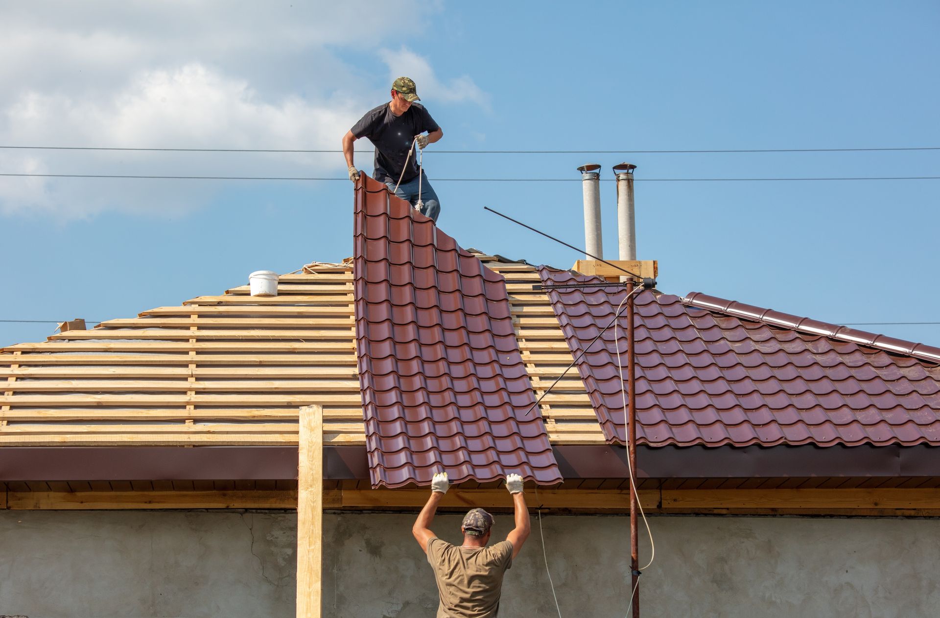 Two men are working on the roof of a house.