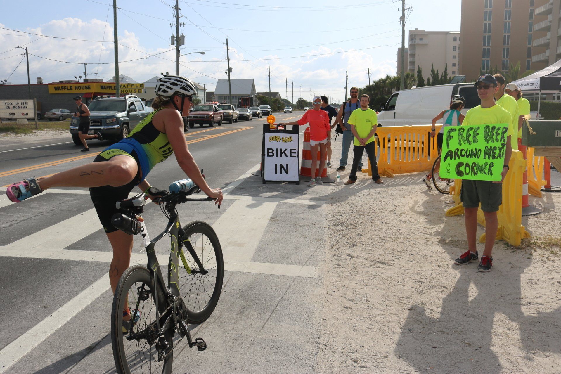 A cyclist performs a dismount near people holding signs that say 