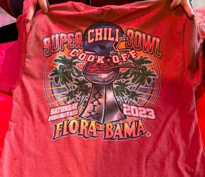 A red t-shirt graphic for the Flora-Bama 2023 Super Chili Bowl Cook-Off featuring a football trophy filled with chili.
