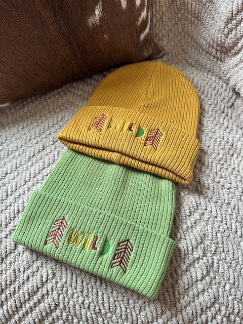 Two knitted beanies, one yellow, one green, with