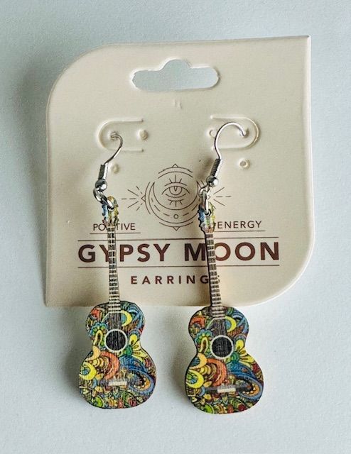 Guitar-shaped earrings with colorful designs hanging from a cardboard tag that says