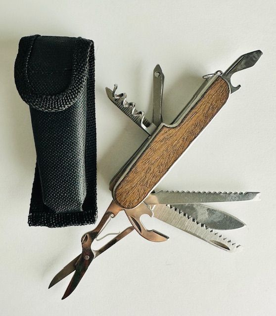 A multi-tool with wood-grain handle and opened tools next to its black carrying case.