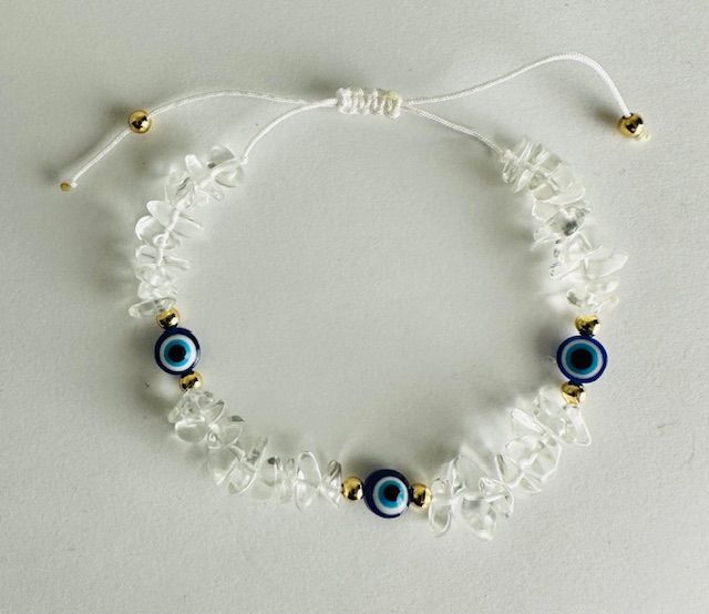 Clear crystal bracelet with three blue evil eye charms and gold accents.