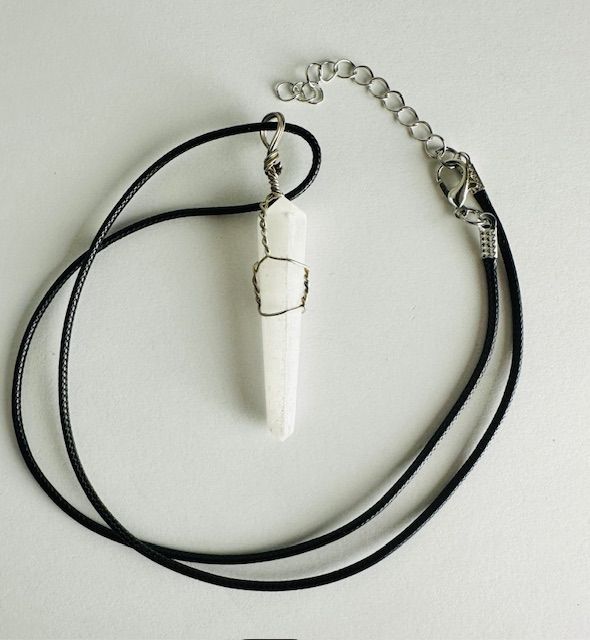 White crystal pendant necklace with black cord.