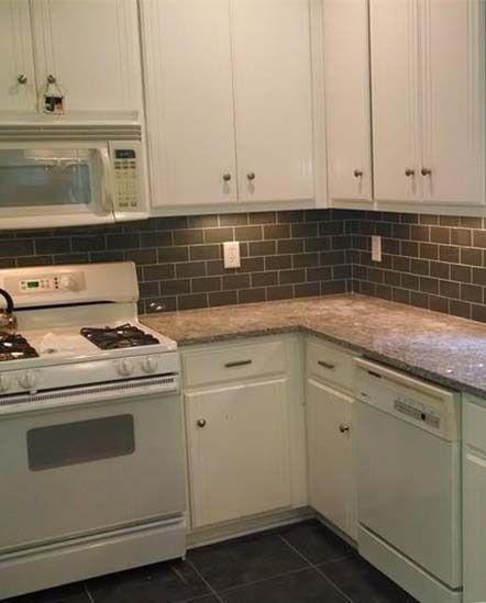 White kitchen with stove, dishwasher, and dark subway tile backsplash