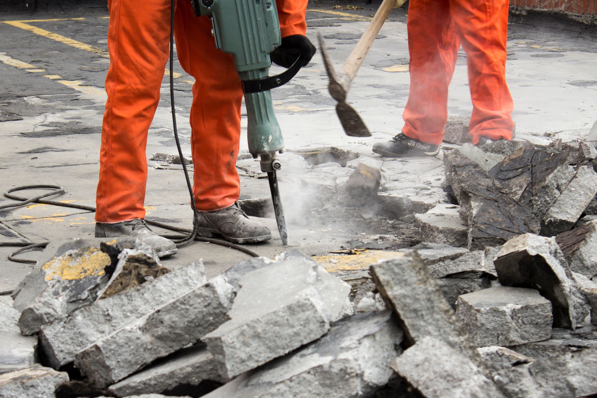 A man is using a jackhammer to break up concrete.
