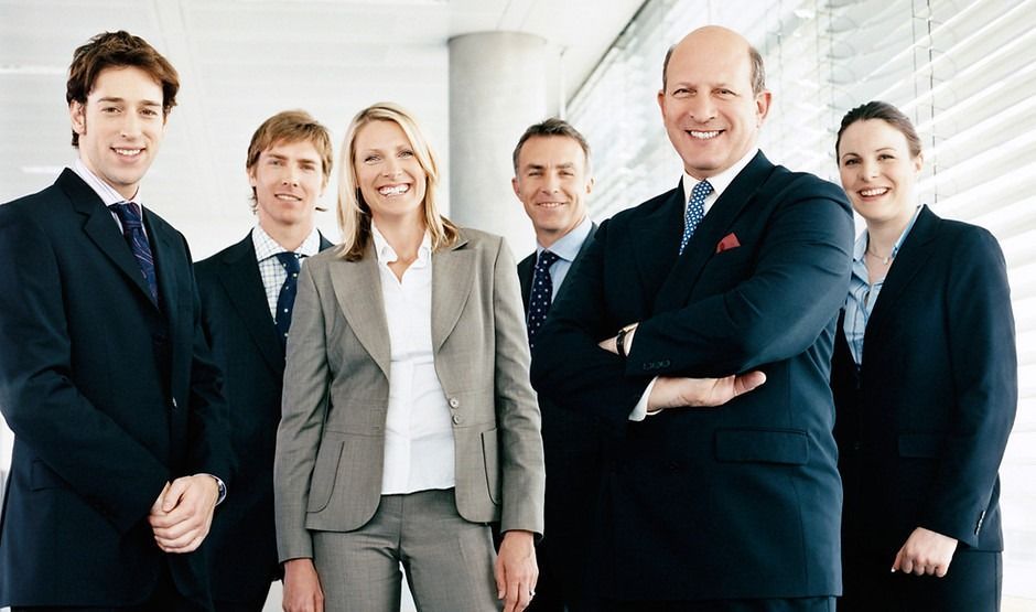 A group of business people posing for a picture with their arms crossed