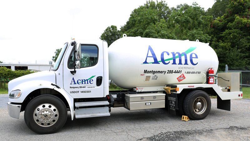A white acme truck is parked on the side of the road