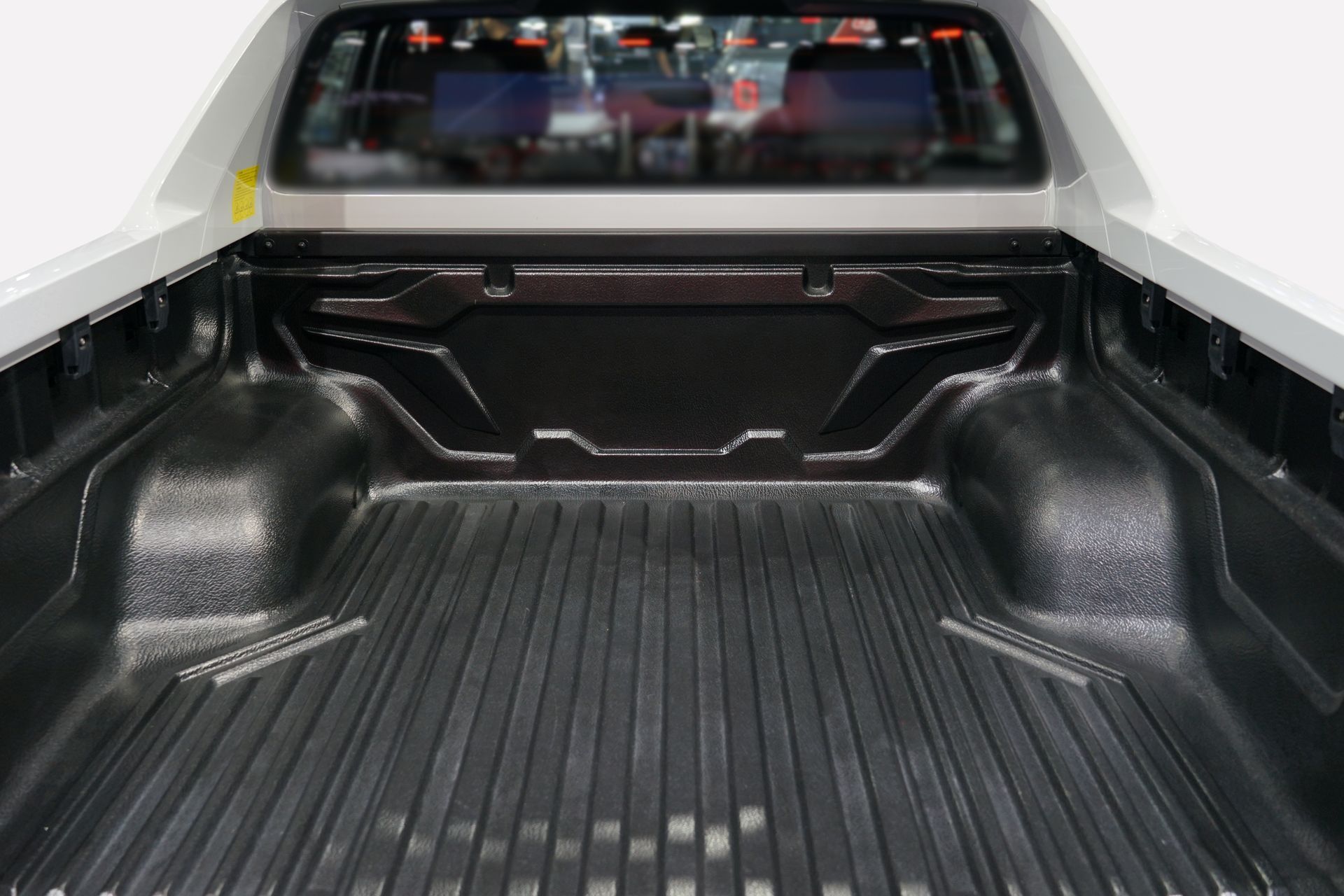 The back of a pickup truck with a rubber bed liner.