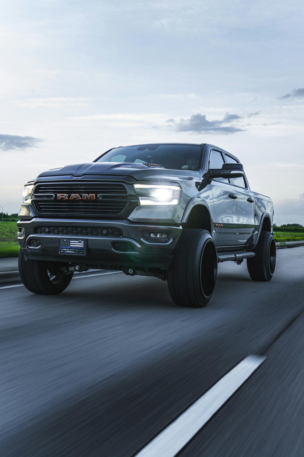 A black ram truck is driving down a highway.
