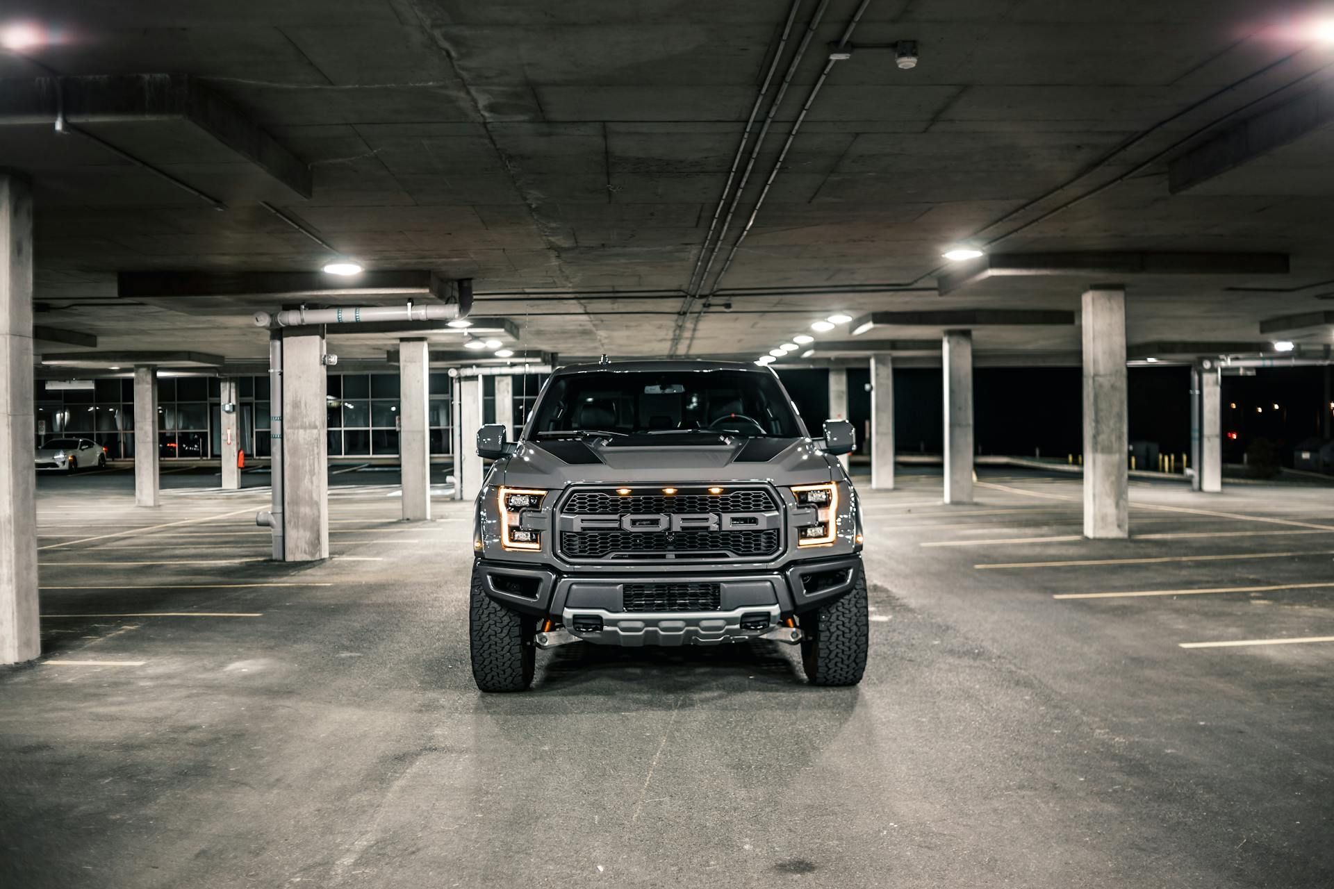 A ford raptor is parked in a parking garage.