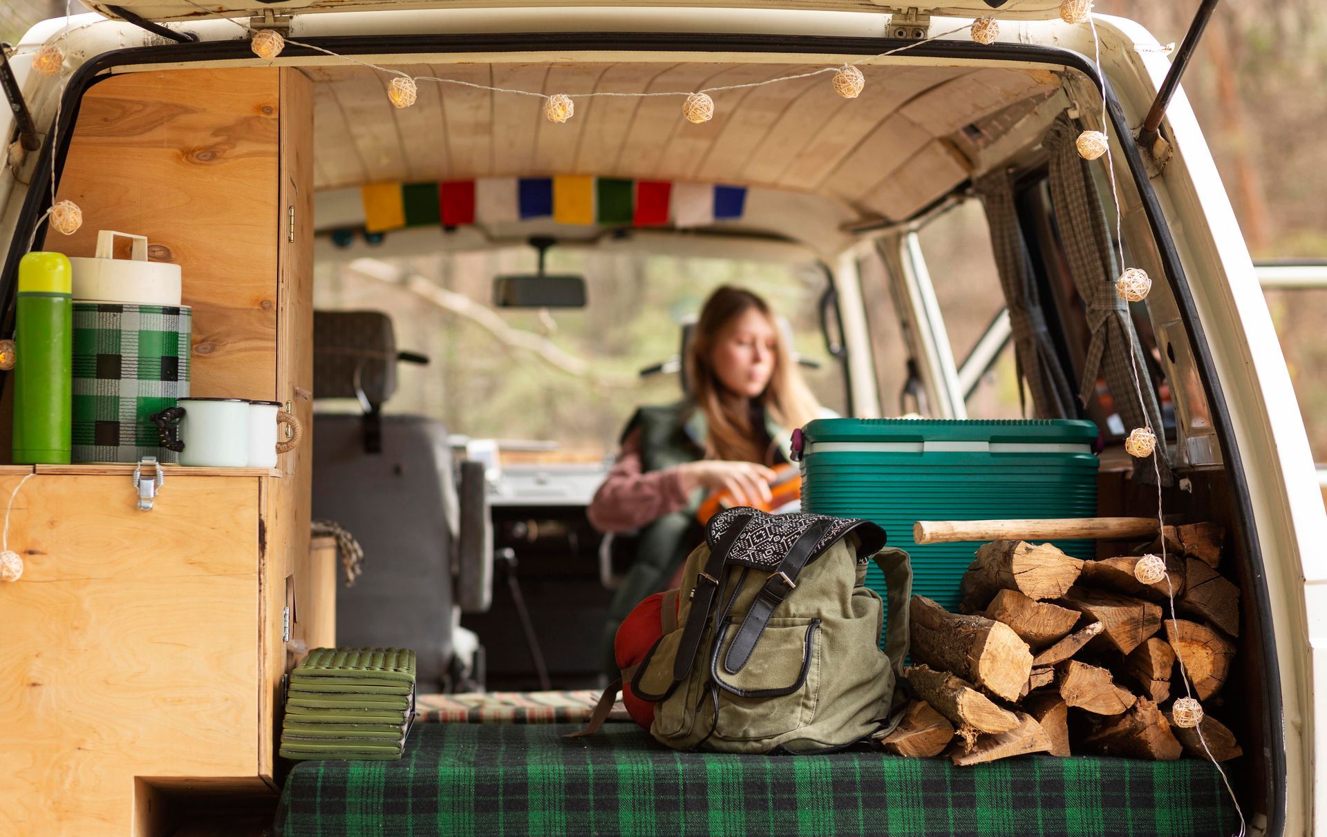 A woman is sitting in the back of a van.
